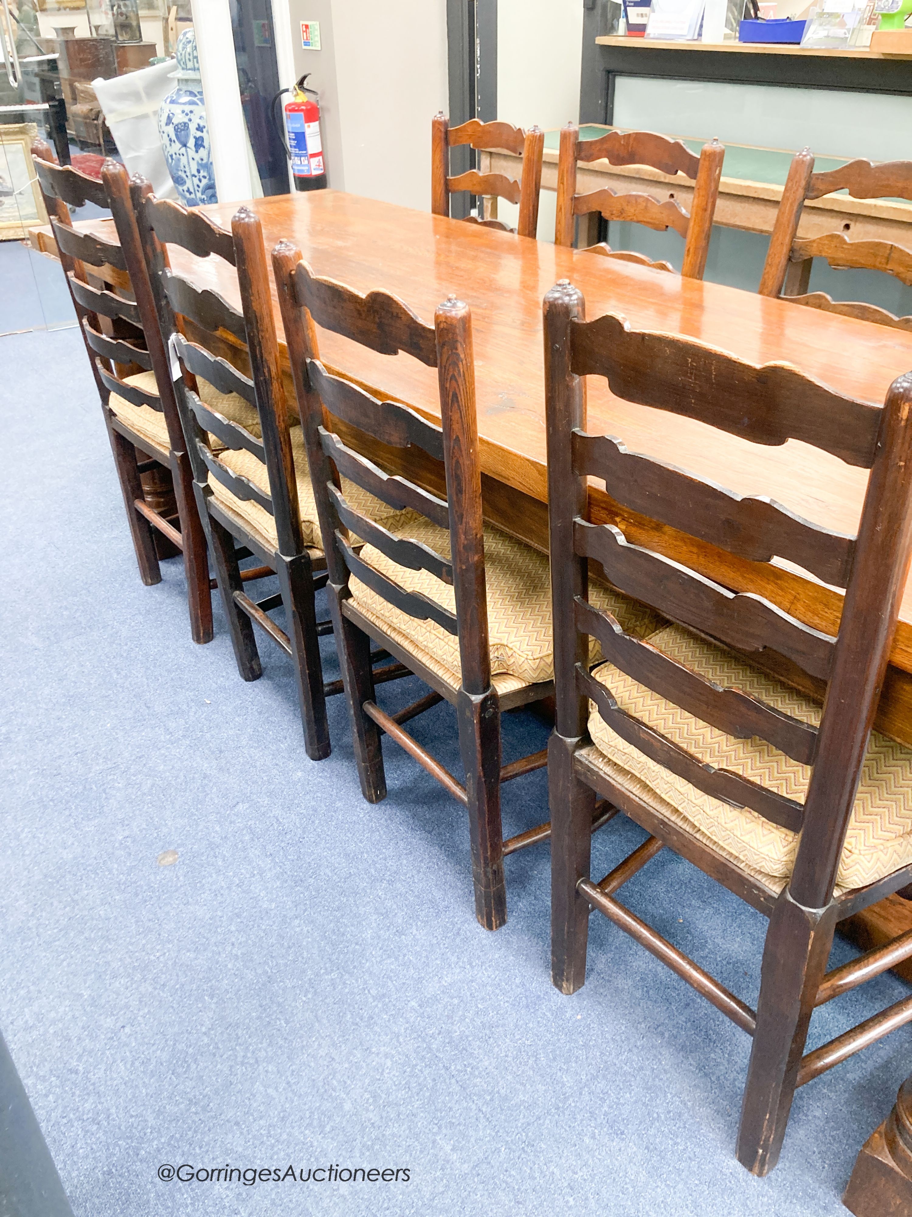 A harlequin set of eight ash rush seat ladder back dining chairs with squab seats